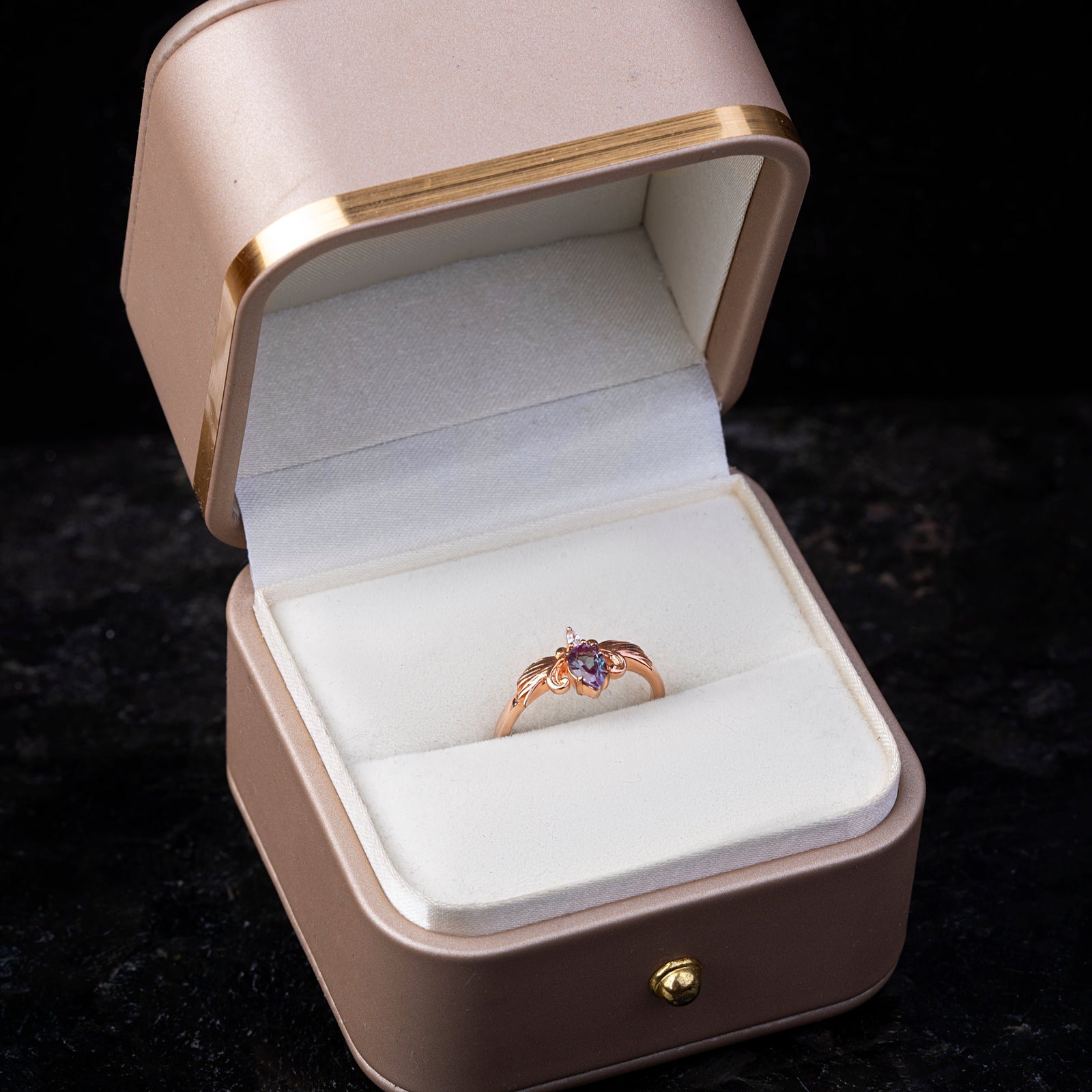 Fifth Avenue Phoenix Heart Alexandrite ring in display box, featuring a pear-cut Alexandrite stone in a rose gold band with intricate wing details.