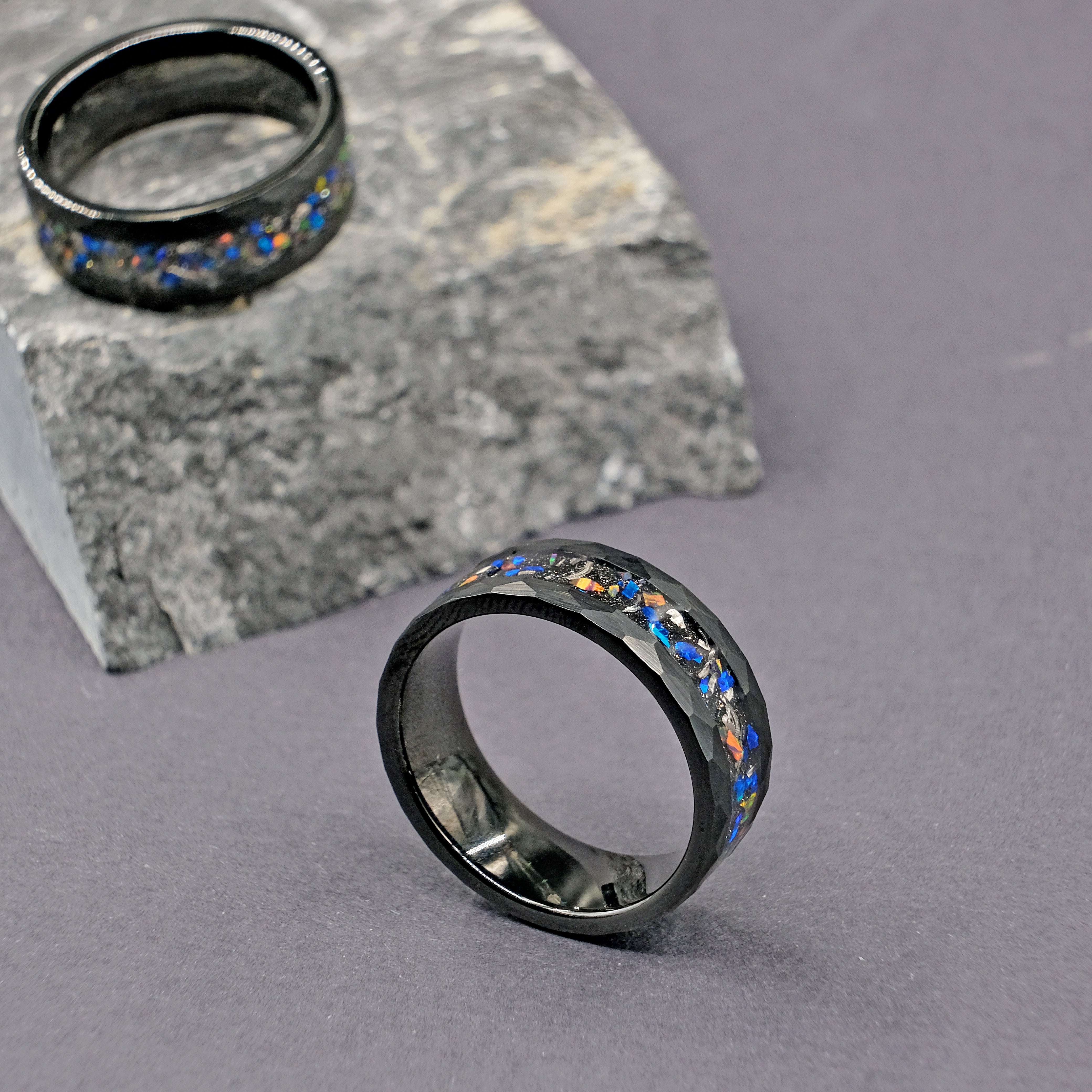 Vertical shot of the Meteorite Black Tungsten Opal Ring set, showcasing the genuine meteorite inlay and luminous opal strip within a hammered tungsten band.