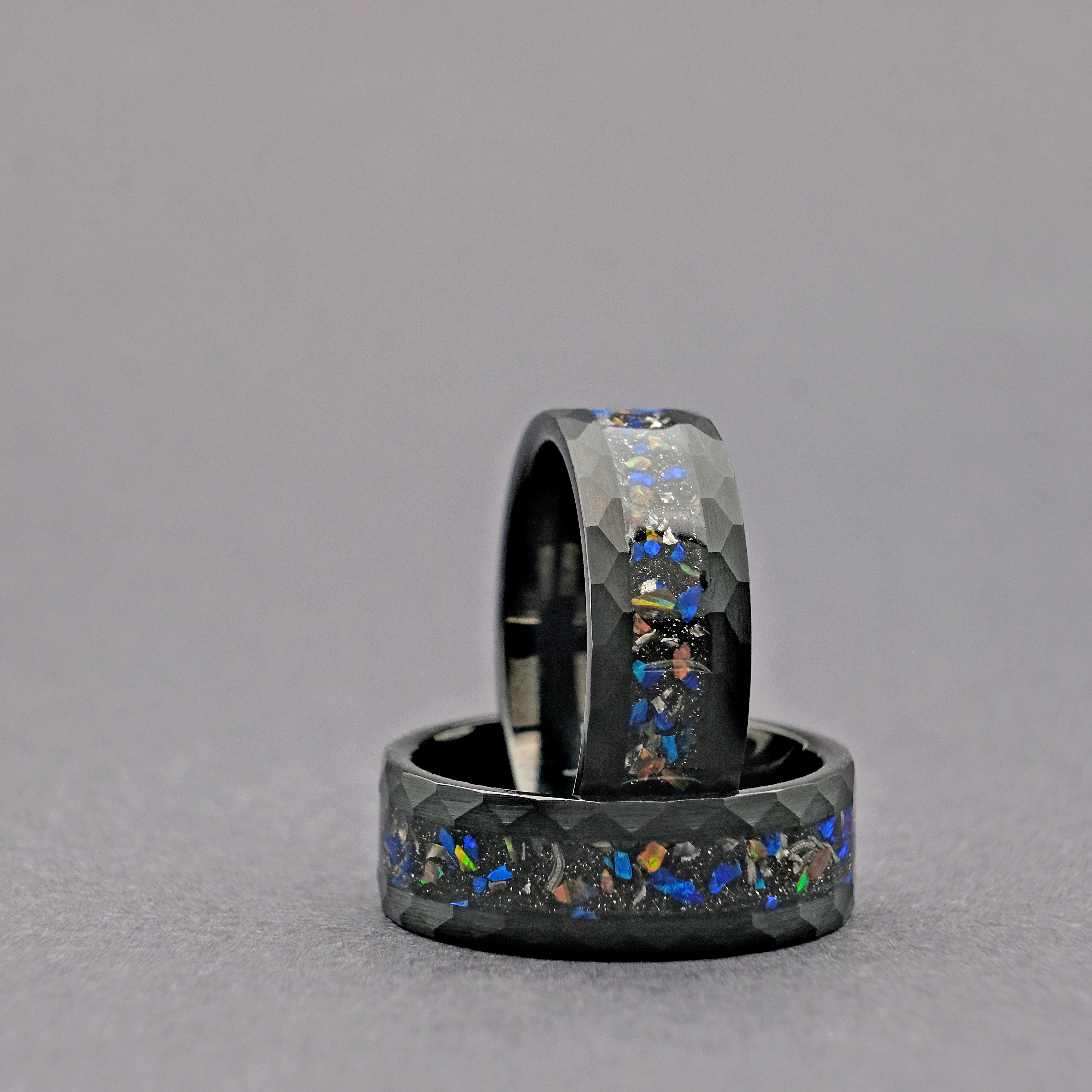 Another vertical shot of the Meteorite Black Tungsten Opal Ring set, emphasizing the rugged texture of the hammered tungsten carbide and the vivid opal accent.
