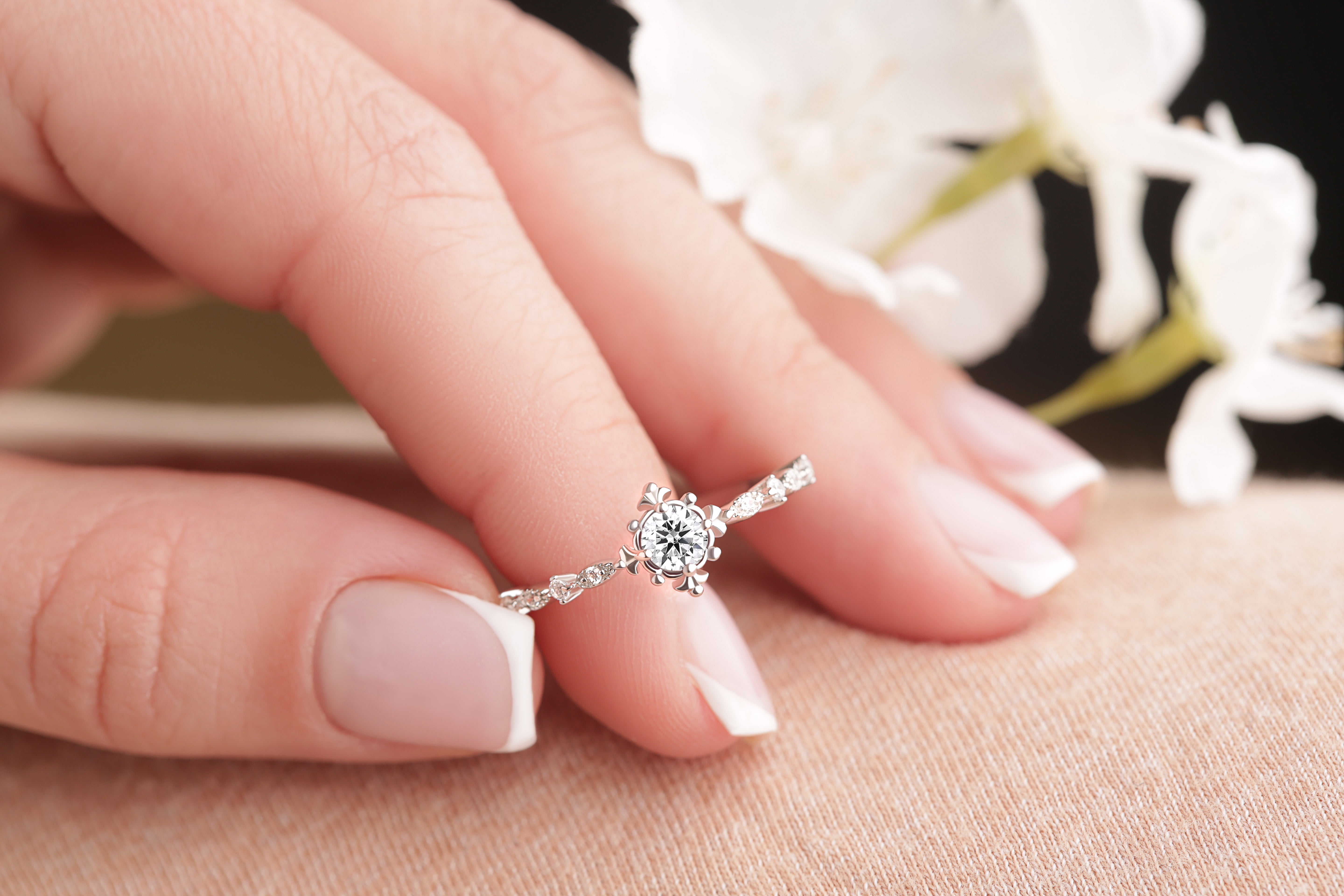 The Brisbane Vintage Glamour Moissanite Ring in silver gold, held delicately by fingertips, emphasizing its Art Deco-inspired elegance and brilliant Moissanite stone.