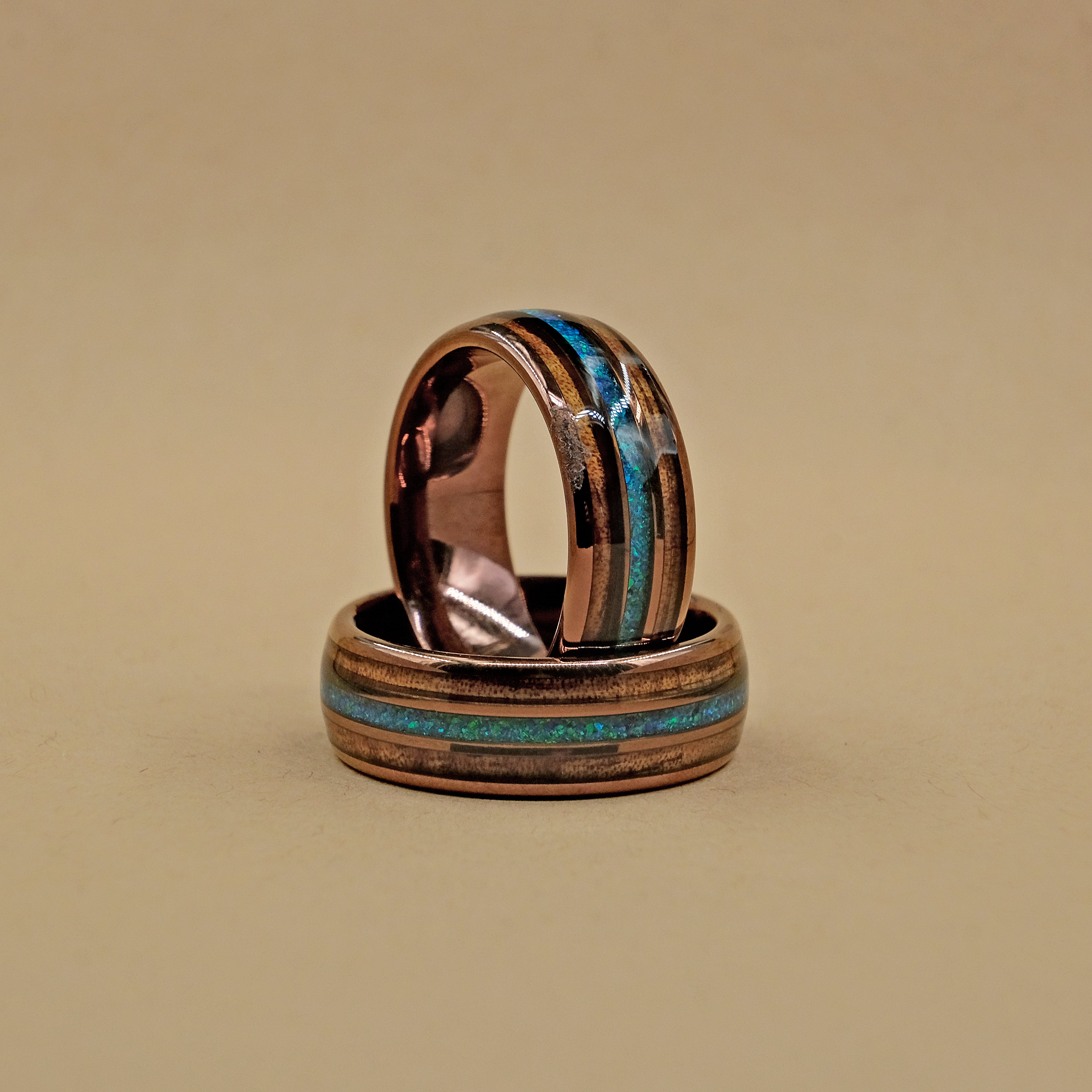 Vertical shot of the Hawaiian Koa Wood Wedding Ring set, showcasing the unique inlay of Koa wood and Bello Opal with 18k rose gold-dipped tungsten carbide.