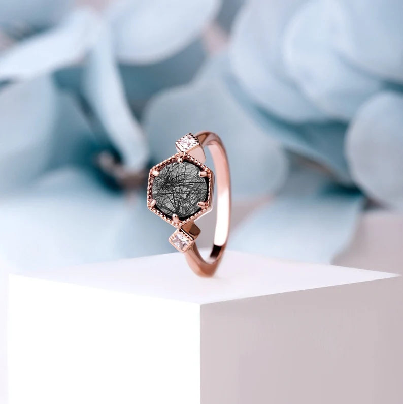 Rose Gold Hectagon Black Rutilated Quartz Ring displayed vertically, highlighting the intricate design and striking gemstone.