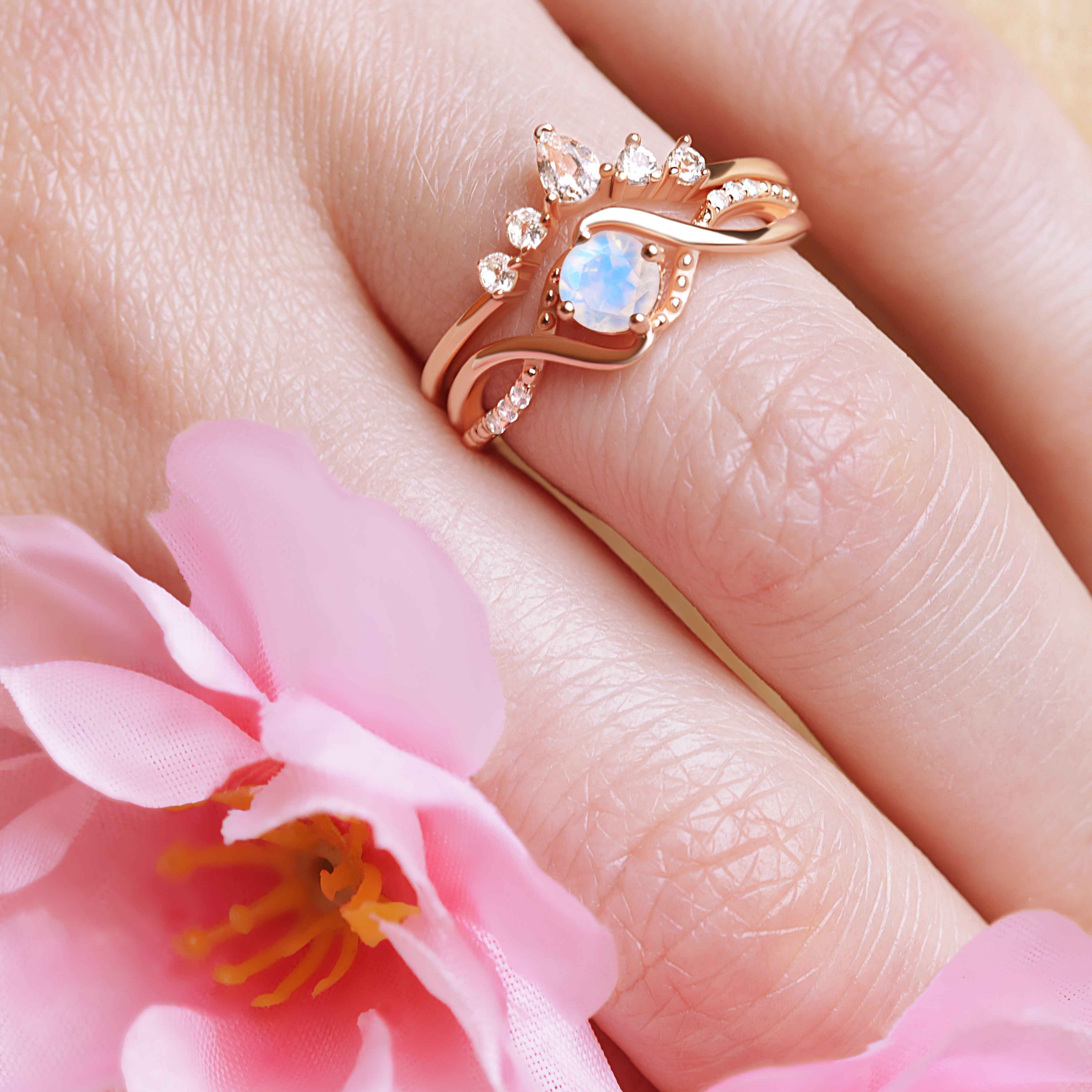 Moonstone Ring Set placed next to a flower, emphasizing the delicate beauty of the moonstone and the ring's elegant design.