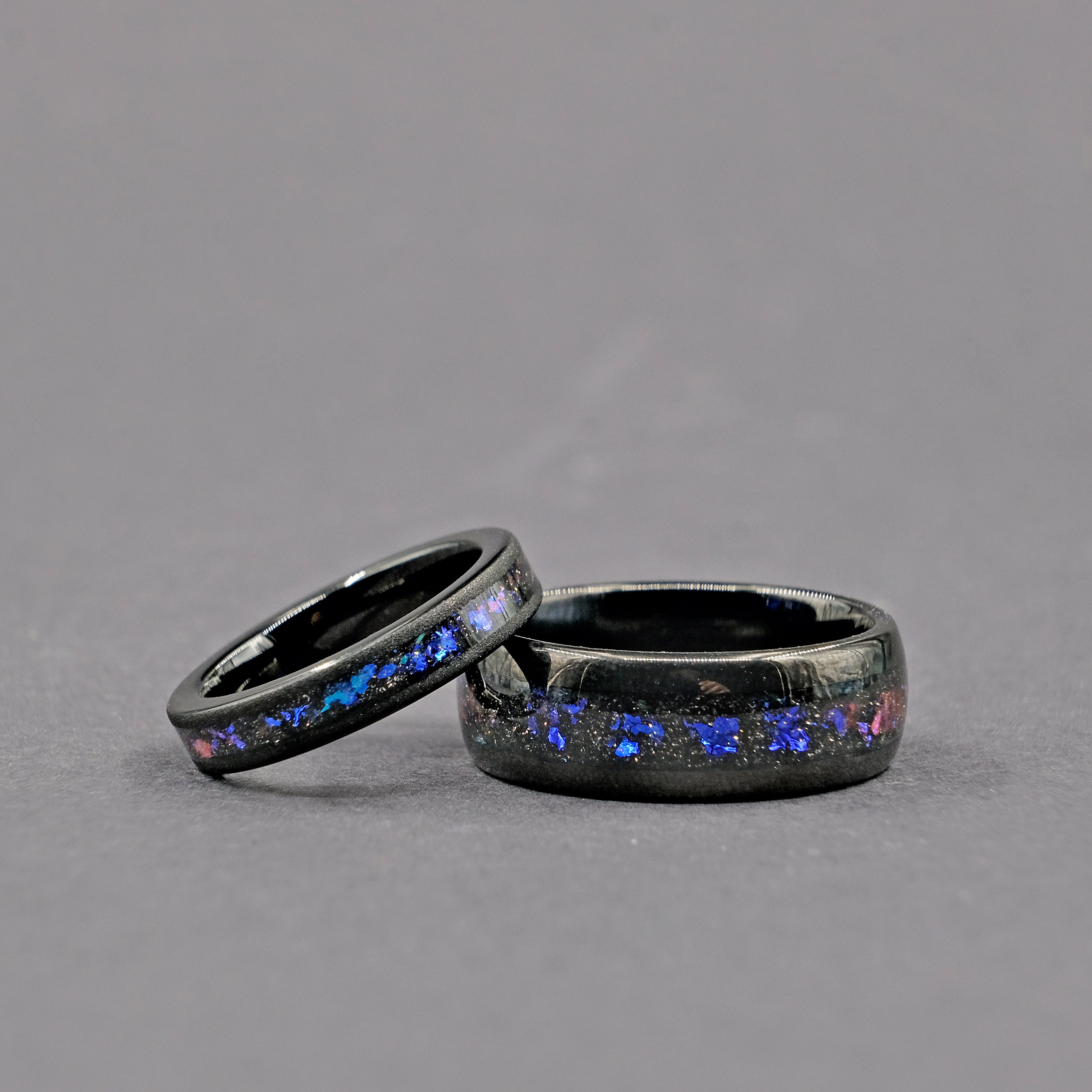 Horizontal shot of the Unique Aqua Tungsten Wedding Ring set, highlighting the shimmering Galaxy Opal centerpiece.