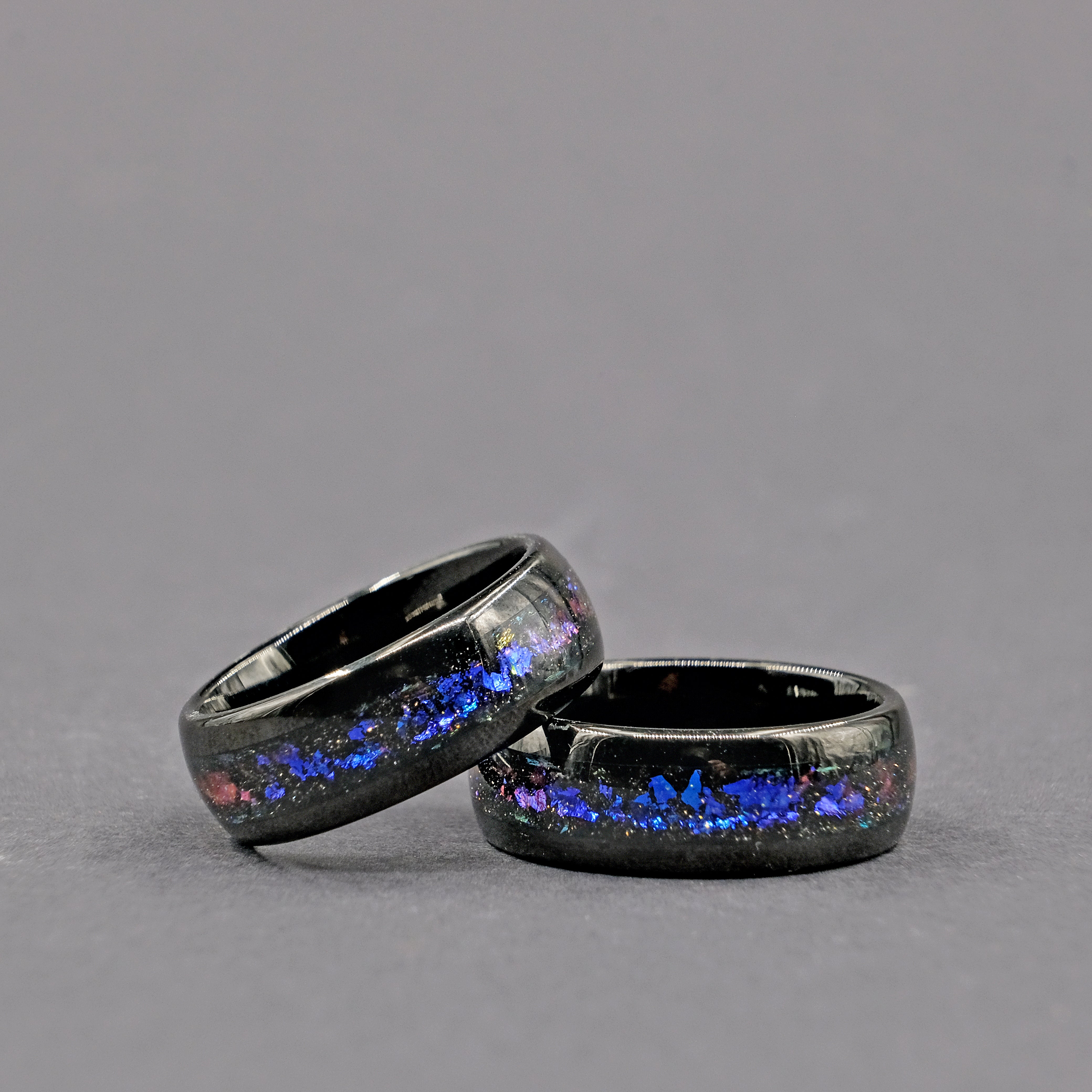 Horizontal shot of the Unique Aqua Tungsten Wedding Ring set, highlighting the shimmering Galaxy Opal centerpiece.