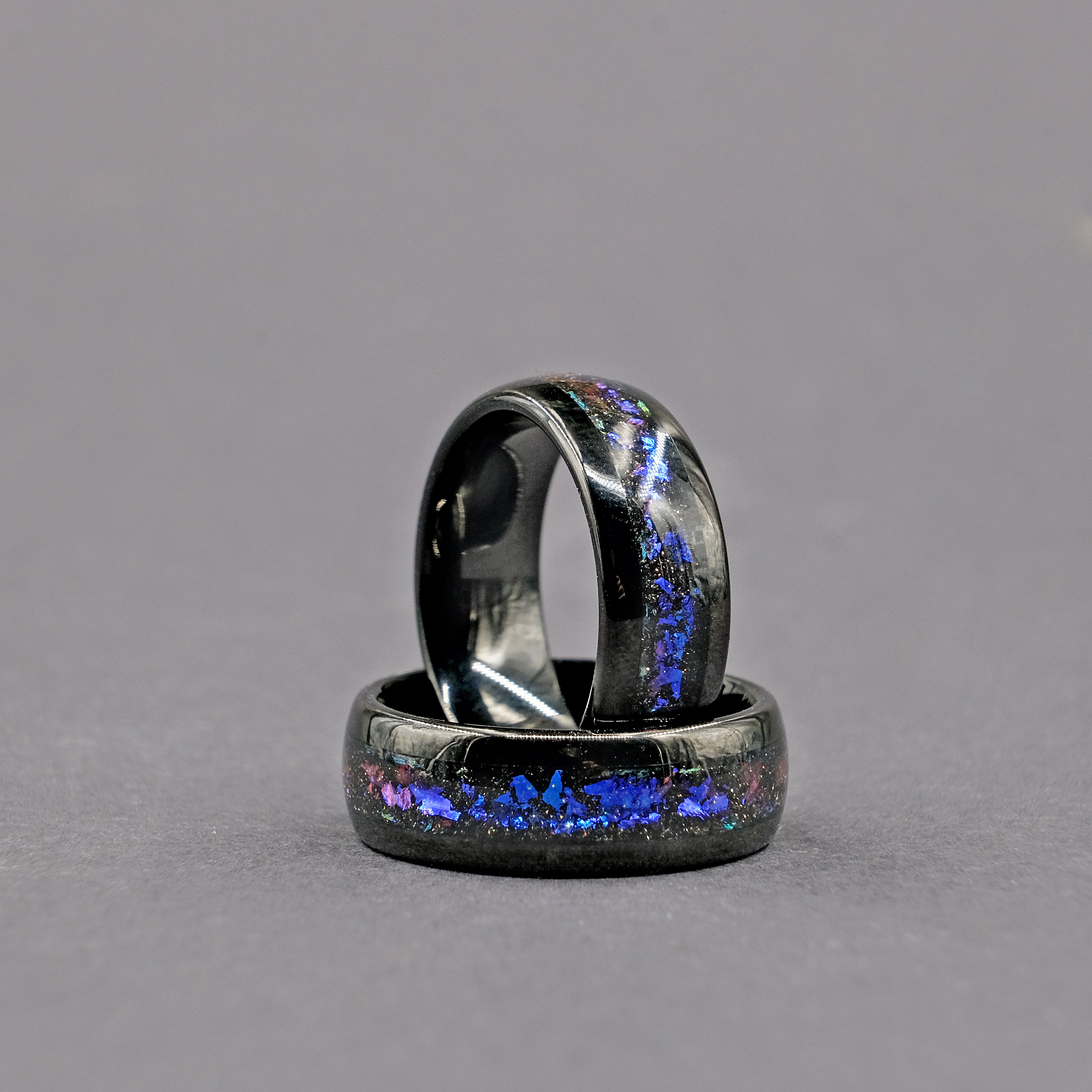 Unique Aqua Tungsten Wedding Ring set vertically, featuring a stunning Galaxy Opal with vibrant colors.