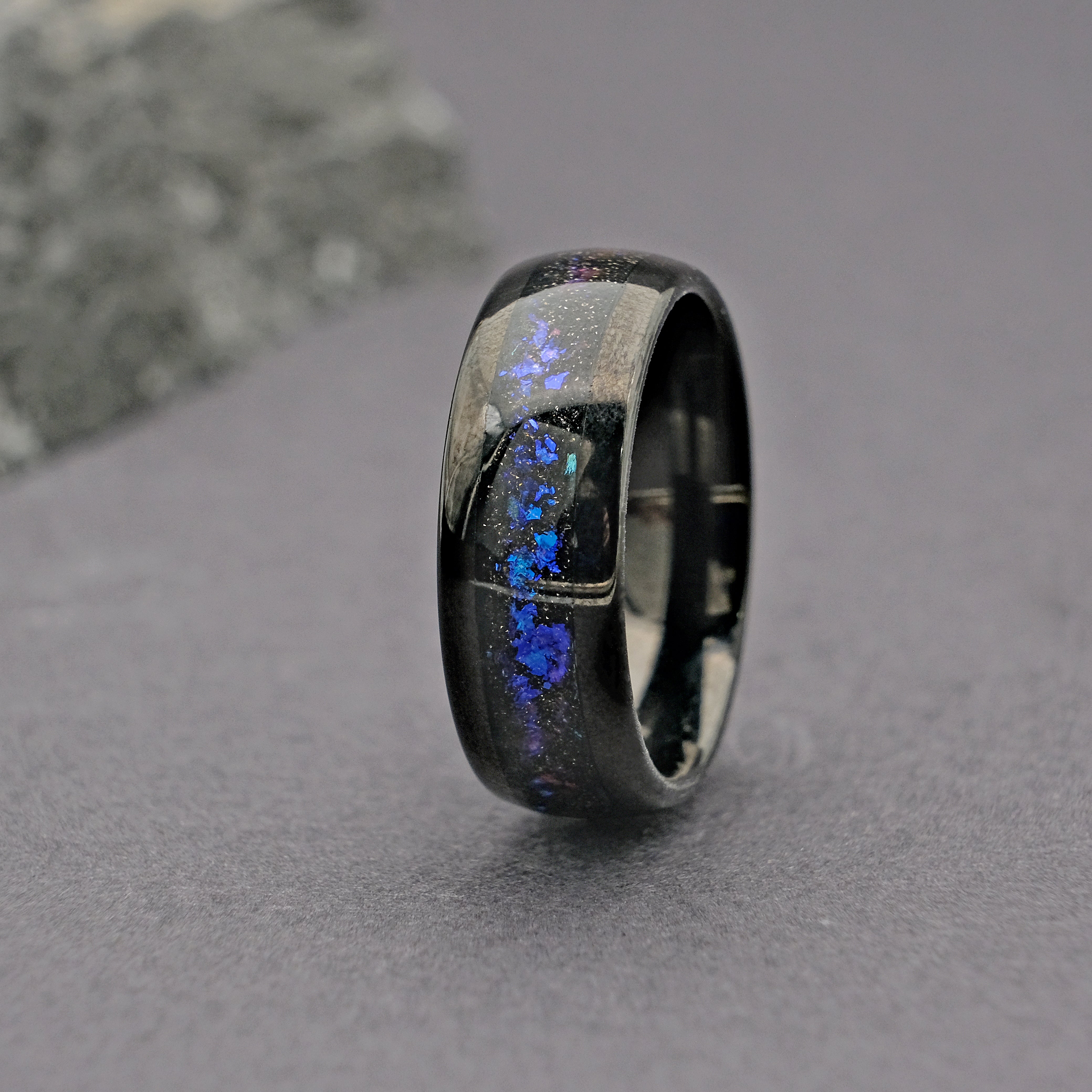 Vertical shot of the Unique Aqua Tungsten Wedding Ring, showcasing the brilliant colors of the Galaxy Opal.