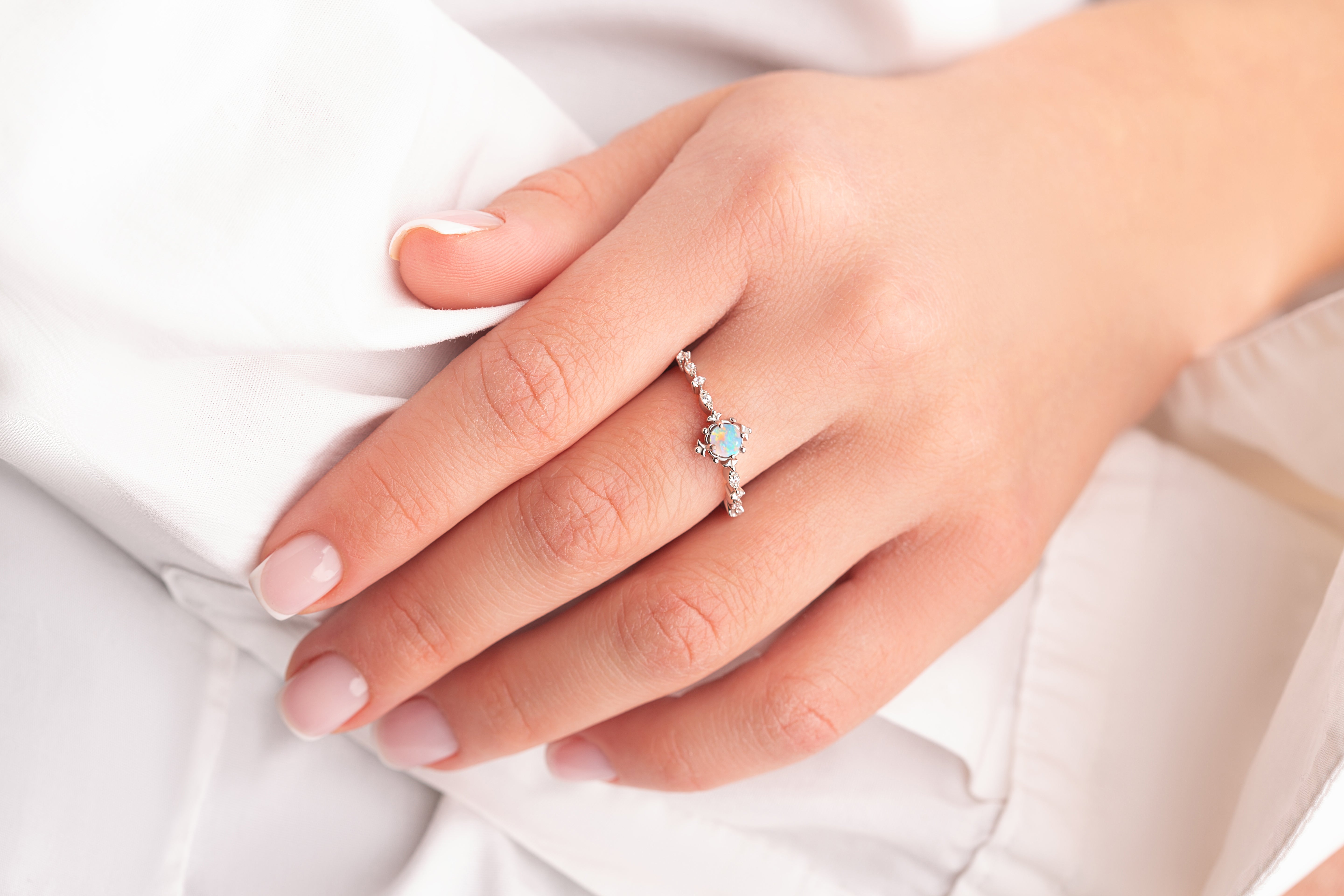 Silver vintage opal engagement ring worn by a model, highlighting its timeless elegance.