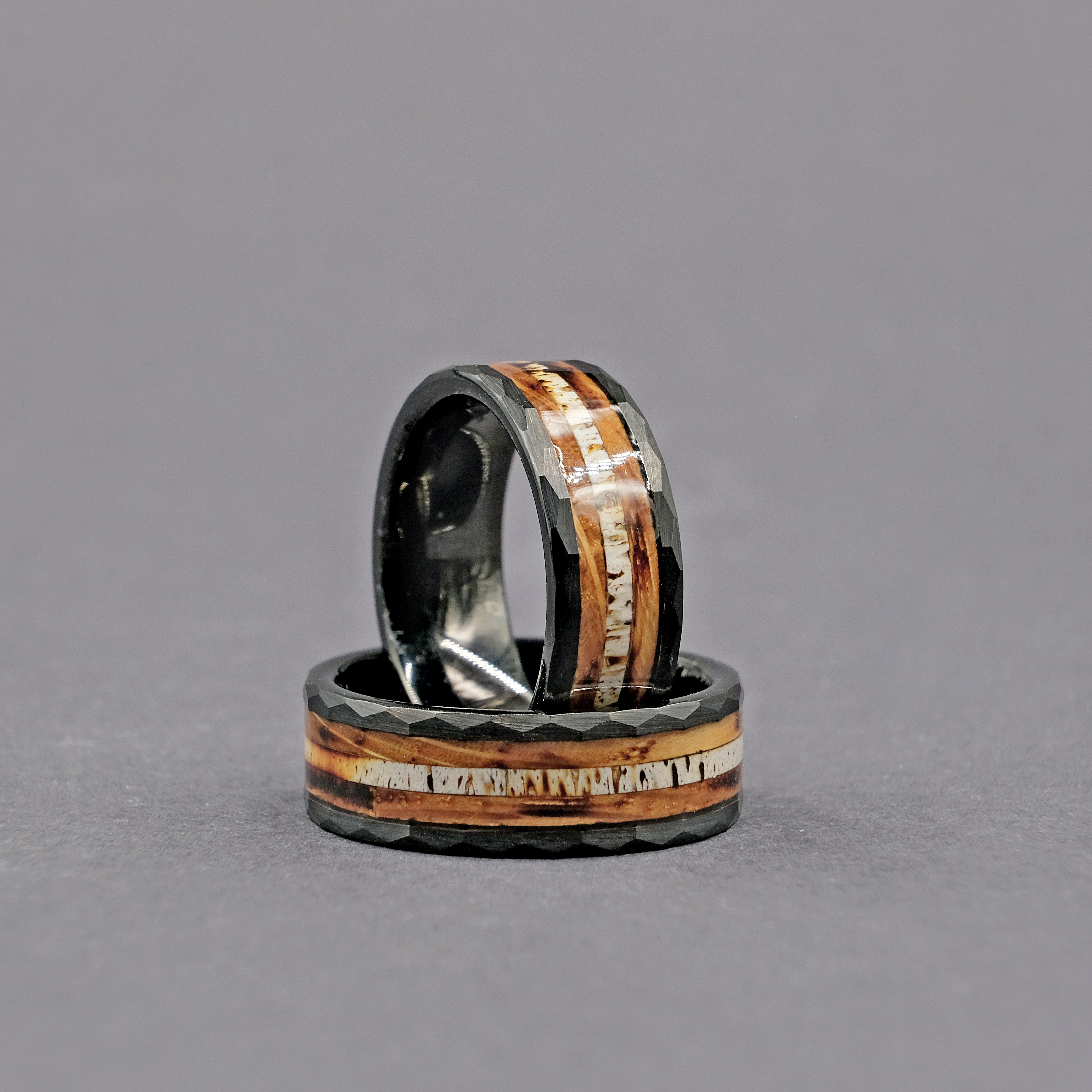 Vertical display of Whiskey Barrel Wedding Rings, highlighting the rich texture of the whiskey barrel wood inlay.