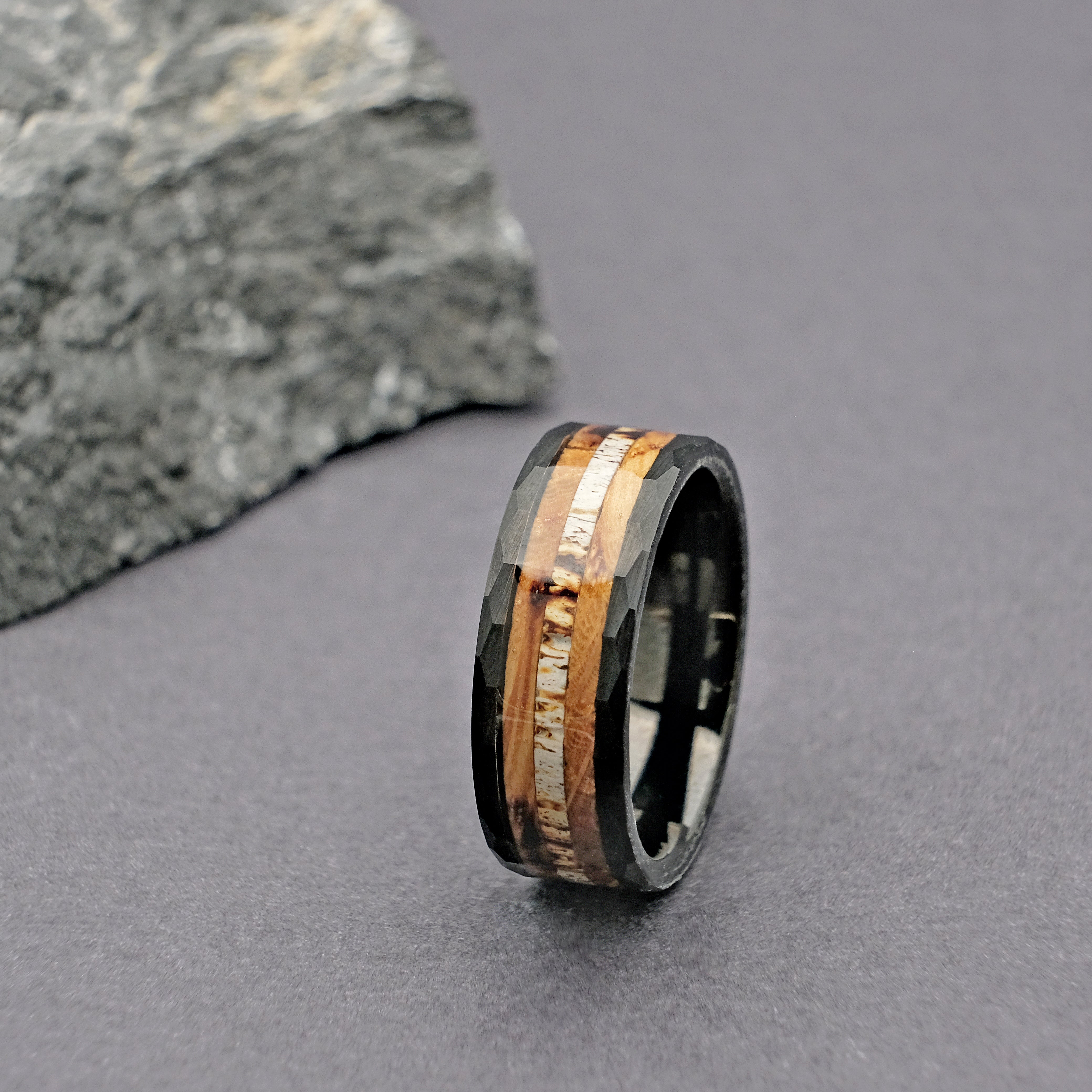 Whiskey Barrel Wedding Ring displayed vertically from a distance, capturing its unique blend of rustic wood and modern tungsten carbide.